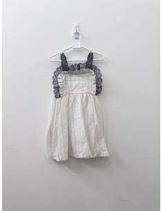 vestido blanco de lino con lineas grises y doradas y detalle de encaje gris en el pecho