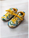 sneakers beige con rayones amarillos, verdes, azules